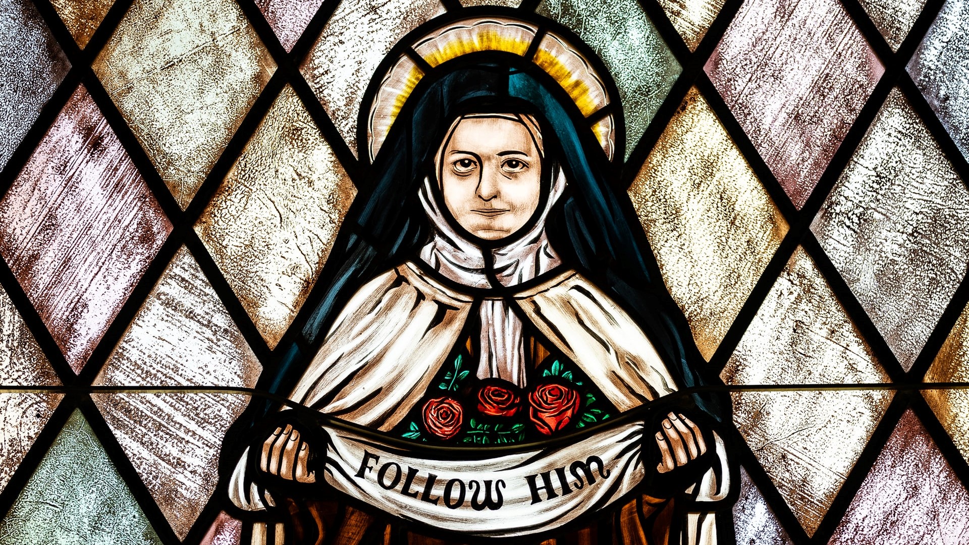 A stained glass image depicting St. Therese of the Child Jesus